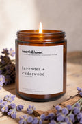 Hearth & Haven lavender and cedarwood candle with lavender flowers on a wooden surface