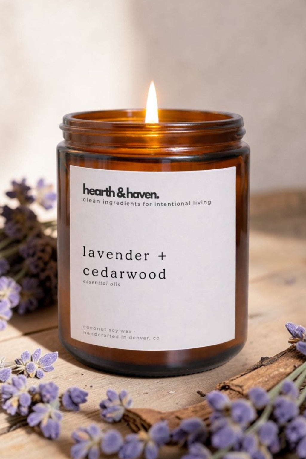 Hearth & Haven lavender and cedarwood candle with lavender flowers on a wooden surface